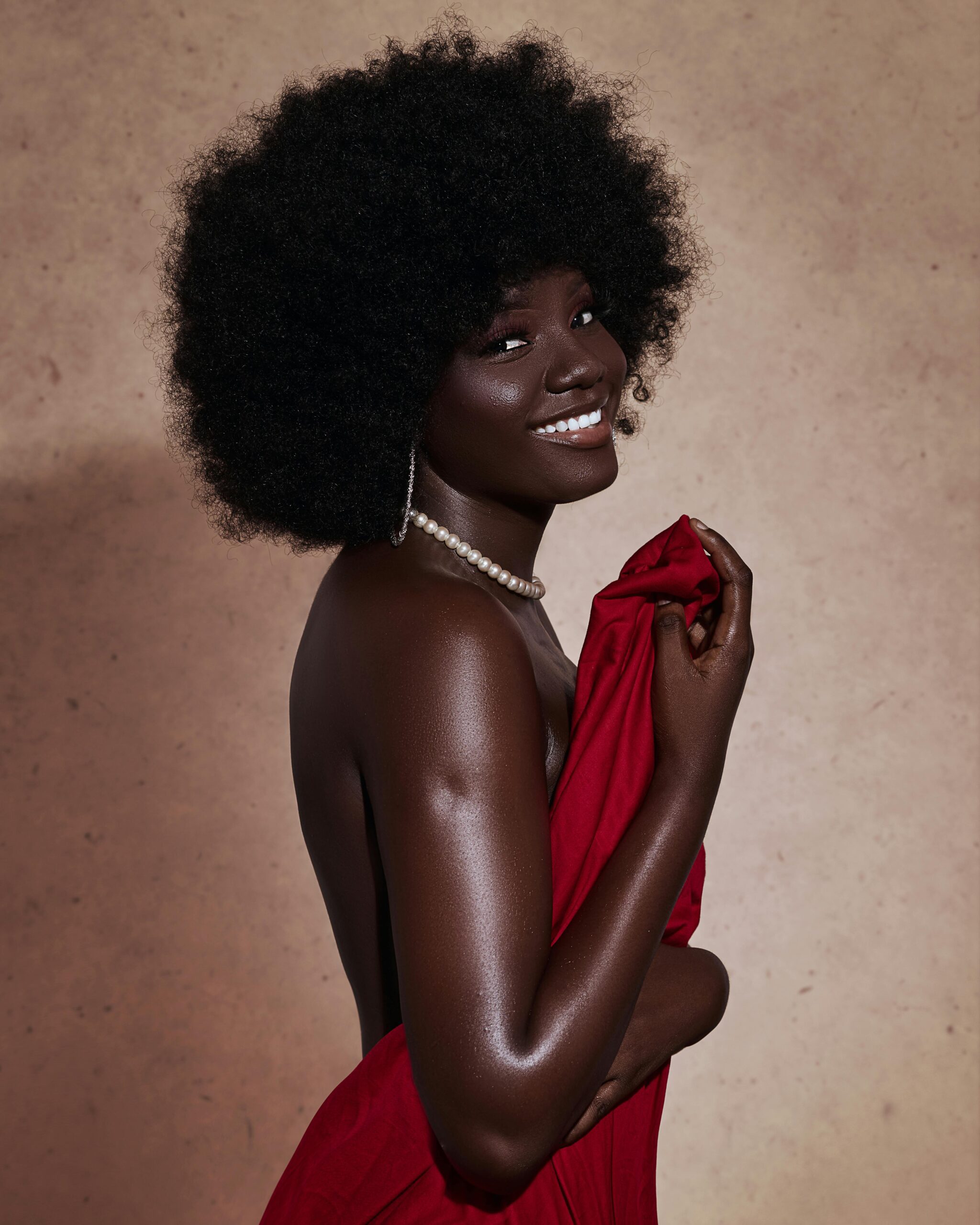 Striking portrait of a stylish black woman with an afro, exuding confidence and charm.